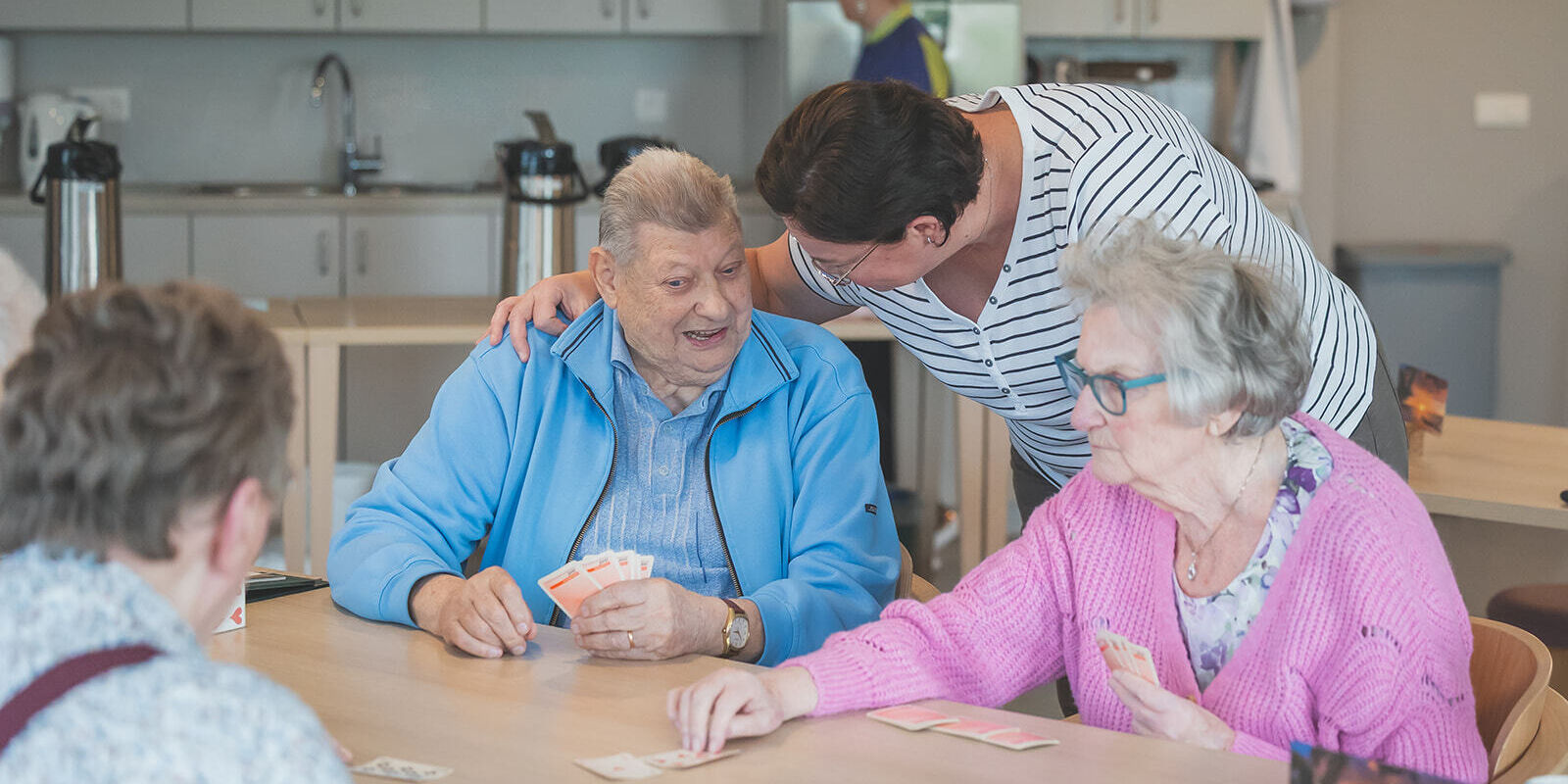 vrouwelijke medewerker in gesprek met mannelijke zorgvrager aan tafel