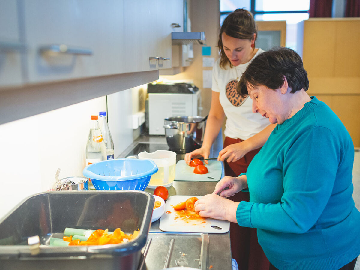 vrouwelijke medewerker aan het koken met vrouwelijke zorgvrager