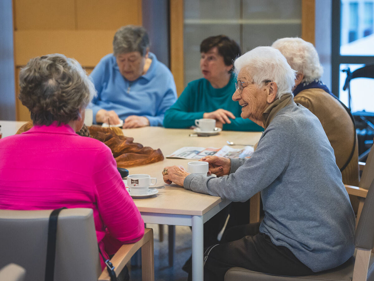 groep zorgvragers drinken koffie aan tafel