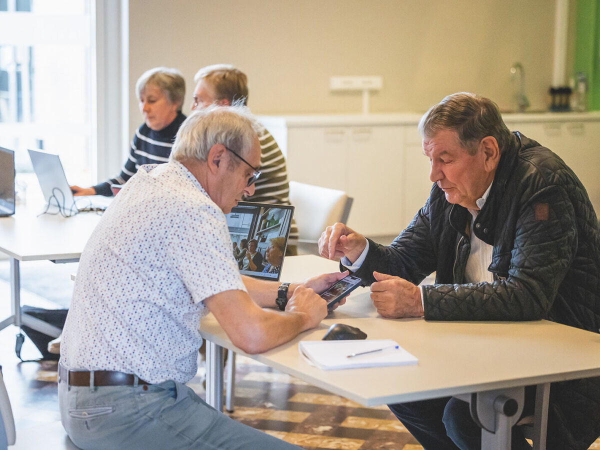 mannelijke vrijwilliger helpt mannelijke zorgvrager in digipunt