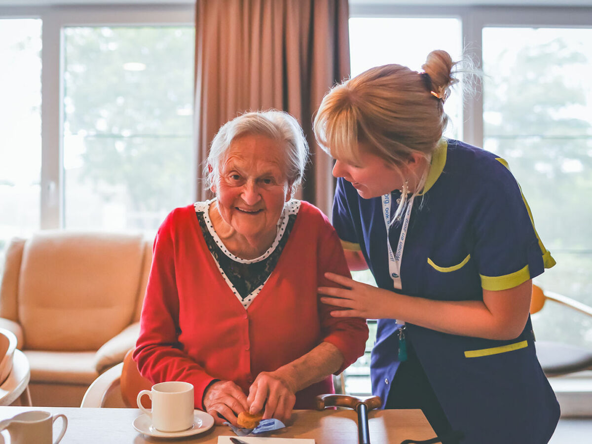 vrouwelijke zorgvrager aan het lachen met vrouwelijke medewerker