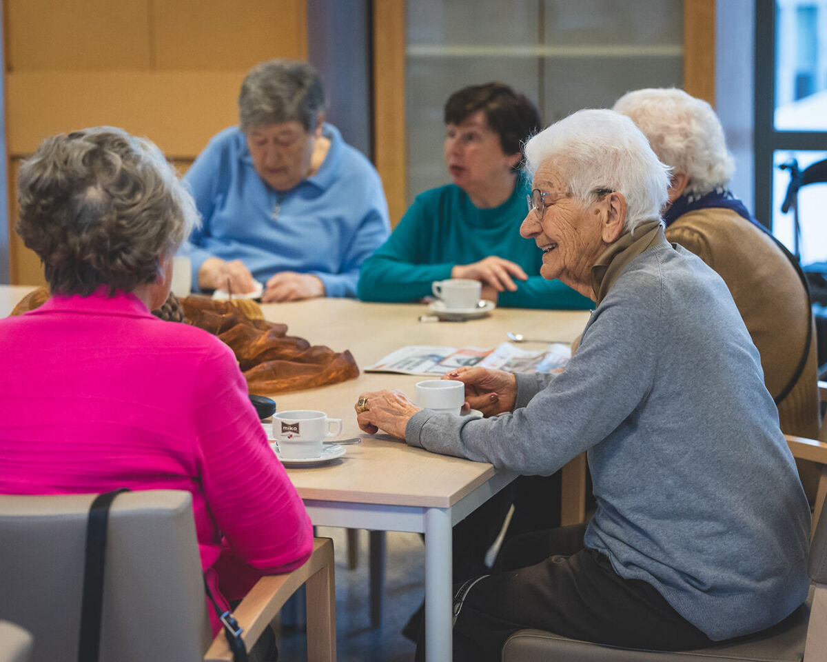 groep zorgvragers drinken koffie aan tafel