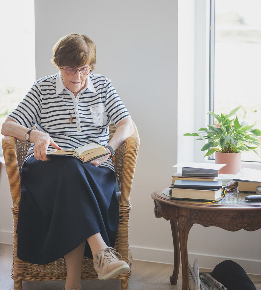 vrouwelijke zorgvrager leest boek in zetel